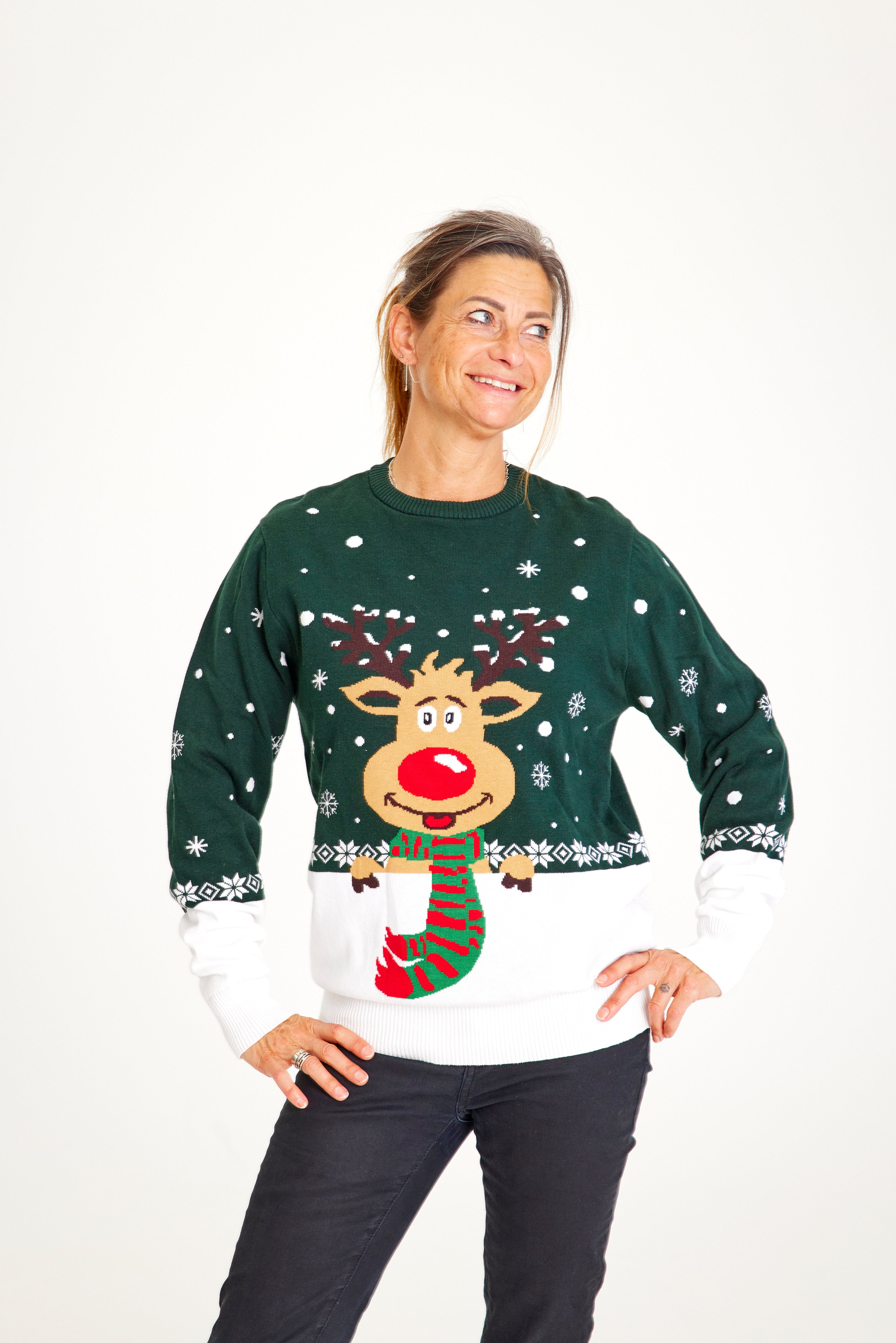Une femme portant un pull de Noël vert et blanc orné de Rudolph.